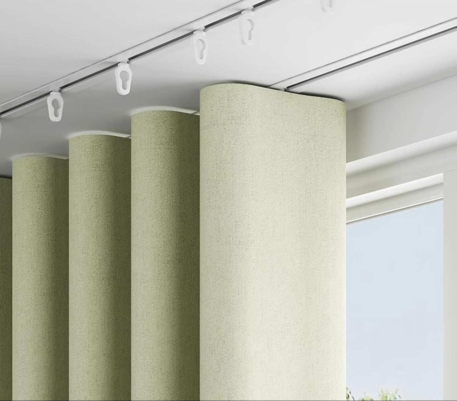 Wave style curtain rail with green curtains and a window in the background